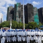 　大規模火災が起きた香港北部の高層住宅群近くに集まった防護服姿の捜索隊員ら＝２９日（共同）