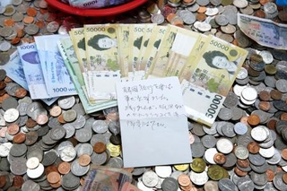 　日本人旅行客が残したとみられる現金１１０万ウォンと支援を託す手紙（韓国赤十字社釜山支社提供、共同）