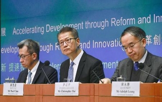 　記者会見で財政予算案について説明する陳茂波財政官（中央）＝２月、香港