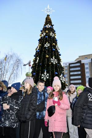 　６日、ウクライナ・ボロディアンカで点灯したクリスマスツリーと集まった市民ら（共同）