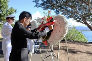 　８日、米ハワイ州フォード島で開かれた日米合同追悼式典で、献花する長徳英晶・駐ホノルル総領事（手前）と、コリンズ米ハワイ方面海軍司令官（共同）