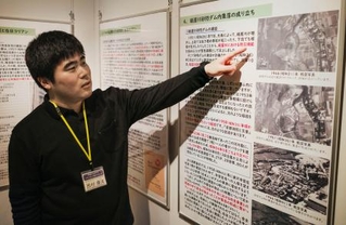 　砂防ダム内集落の歴史を解説する特別展について説明するＮＰＯ法人「くらしネット２１」の西村優汰さん＝１１月、京都市北区