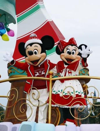 　東京ディズニーランドのクリスマスを祝うパレードで手を振るミッキーマウスとミニーマウス＝２０１５年１１月、千葉県浦安市