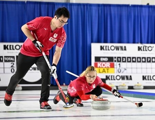 　混合ダブルス１次Ｌ　ドイツ戦の第２エンド、ショットを放つ小穴桃里。左は青木豪＝ケロウナ（共同）