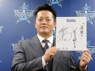 　契約交渉を終え、記者会見で色紙を手にするＤｅＮＡの牧＝１６日、横浜市の球団事務所