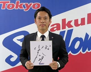 　契約更改交渉を終え、来季の抱負を記した色紙を手にするヤクルト・小川＝１８日、東京都内の球団事務所