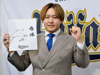 　契約更改を終え、来季の目標を書いた色紙を手にポーズをとるオリックスの宮城＝１８日、大阪市