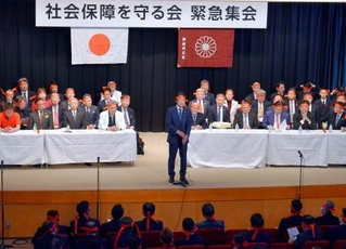 　自民党本部で開かれた緊急集会であいさつする田村元厚労相（中央）＝１８日午後、東京・永田町