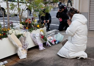 　王将フードサービス本社前で手を合わせる遺族の大東真弓さん＝１９日朝、京都市山科区