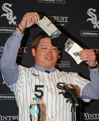 　米大リーグ、ホワイトソックスの入団記者会見で靴下を掲げる村上宗隆内野手＝２２日、シカゴ（共同）