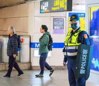 　爆破予告を受けて、地下鉄の台北駅周辺を警戒する警察官＝２２日、台北市（共同）