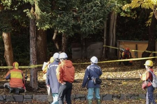 　「緊急銃猟」で銃を構える猟友会のハンター（右奥）ら＝１０月、札幌市西区