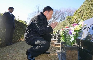 　宮沢みきおさん一家の墓前で手を合わせる警視庁成城署の元署長土田猛さん＝３０日午前、埼玉県新座市