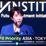 　会場内のモニターに映し出された高市首相＝１日午前、東京都港区