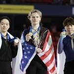 　２０２４年１２月、フィギュアスケート、ＧＰファイナルの男子表彰式でメダルを掲げる（左から）２位の鍵山優真、優勝のイリア・マリニン、３位の佐藤駿＝グルノーブル（共同）