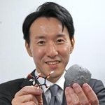 　小惑星ベンヌ（右）とリボースの模型を手にする東北大の古川善博准教授＝１日、東京都千代田区