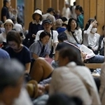 　大阪メトロ中央線が運転見合わせとなり、大屋根リングの下で休憩する人たち＝８月１４日午前１時８分、大阪市此花区の夢洲