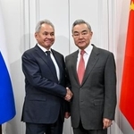 　ロシアのショイグ安全保障会議書記（左）と握手する中国の王毅外相＝２日、モスクワ（新華社＝共同）