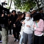 　生活必需品や貴重品を取るために火災があった高層住宅群に向かうお年寄り（手前左）＝３日、香港（共同）