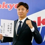 　契約更改交渉を終え、来季の目標を書いた色紙を掲げポーズをとるヤクルト・奥川＝５日、東京都内の球団事務所