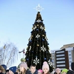 　６日、ウクライナ・ボロディアンカで点灯したクリスマスツリーと集まった市民ら（共同）