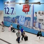 　駅構内の壁一面に張られた立法会選挙の投票を呼びかける広告＝６日、香港（共同）