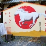 　来年の干支「午」にかけ替えられた丹生官省符神社の大絵馬。左は宮崎志郎宮司＝７日、和歌山県九度山町