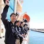 　オーストラリア西岸のフリマントルを出港し、観測船「しらせ」の甲板で見送りに来た人たちに帽子を振る隊員ら＝８日（南極観測隊同行記者撮影）