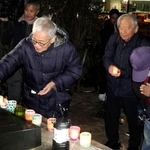 　不戦を誓う集会で、献灯する参加者＝８日午後、長崎市