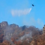 　群馬県富岡市の妙義山で消火活動するヘリコプター＝９日午前８時３１分