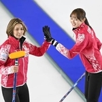 　女子１次Ｌ　エストニア戦の第４エンド、ショットを決めタッチを交わす吉村（左）と小林＝ケロウナ（共同）