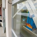 　学校が再開し、登校する青森県八戸市立江南小の児童。手前は地震でひび割れたガラス＝１０日午前７時３７分