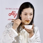 　記者会見でギョーザのあんかけ丼を試食する荒川静香さん＝１０日、東京都内