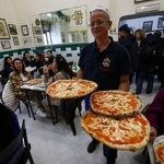 　イタリア・ナポリのレストランで運ばれるピザ＝５日（ロイター＝共同）