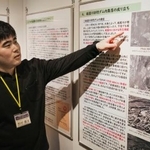 　砂防ダム内集落の歴史を解説する特別展について説明するＮＰＯ法人「くらしネット２１」の西村優汰さん＝１１月、京都市北区