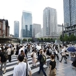 　東京・丸の内を歩く人たち＝７月
