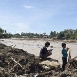 　２日、豪雨で崩れたモスクのがれきに乗る子どもたち＝インドネシア西スマトラ州パダン