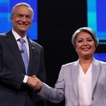 　テレビ討論会に参加し握手を交わすチリ大統領候補のハラ前労働・社会保障相（右）とカスト元下院議員＝９日、サンティアゴ（ロイター＝共同）