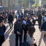 　リンゴ日報の創業者、黎智英氏への判決公判が開かれる裁判所前を警戒する治安当局者ら＝１５日、香港（共同）