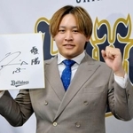 　契約更改を終え、来季の目標を書いた色紙を手にポーズをとるオリックスの宮城＝１８日、大阪市