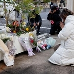 　王将フードサービス本社前で手を合わせる遺族の大東真弓さん＝１９日朝、京都市山科区