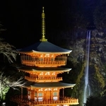　試験点灯が行われた「那智の滝」と青岸渡寺の「三重塔」＝１９日夜、和歌山県那智勝浦町