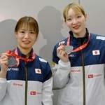 　メダルを手に写真に納まるバドミントン女子ダブルスの福島由紀（左）と松本麻佑＝２２日、成田空港