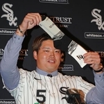 　米大リーグ、ホワイトソックスの入団記者会見で靴下を掲げる村上宗隆内野手＝２２日、シカゴ（共同）