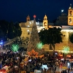 　イエス・キリスト生誕の地とされるパレスチナ自治区ベツレヘムで、クリスマスツリーが飾られた広場に集まった市民ら＝２４日（共同）