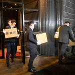 　運営会社の関係先を家宅捜索し、段ボールを運び出す警視庁の捜査員ら＝２５日午後５時２６分、東京都港区