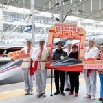 　中国陝西省で新たに開業した高速鉄道の延安駅で記念撮影する乗客ら＝２６日（新華社＝共同）