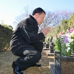 　宮沢みきおさん一家の墓前で手を合わせる警視庁成城署の元署長土田猛さん＝３０日午前、埼玉県新座市