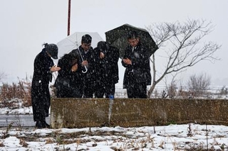 　能登半島地震で犠牲になった親族の自宅跡で手を合わせる人たち＝１日午後１時５８分、石川県珠洲市宝立町