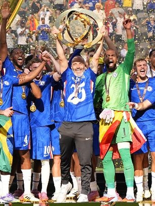 　クラブワールドカップで優勝を果たし、トロフィーを掲げて喜ぶチェルシーのマレスカ監督（中央）＝２０２５年７月（共同）